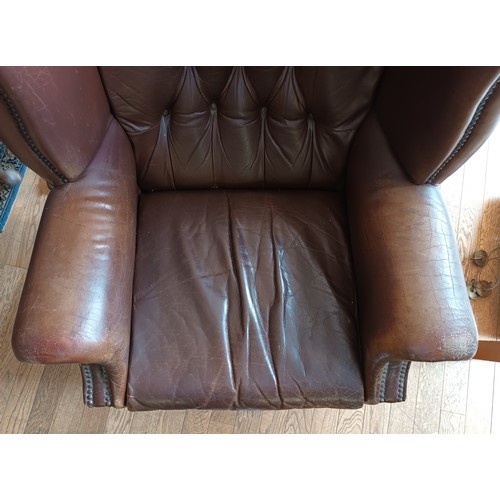 338 - A pair of Georgian style wingback armchairs, upholstered in tan leather with buttoned backs, raised ... 