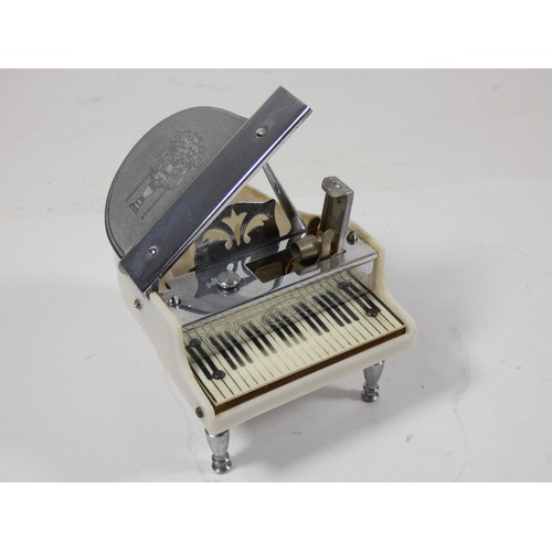 333 - A 1950s figural petrol table cigarette lighter, in the form of a grand piano, pressing the keys oper... 