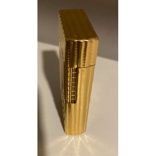 335 - A Dunhill 70 pocket cigarette lighter, gold plated with bark effect decoration.