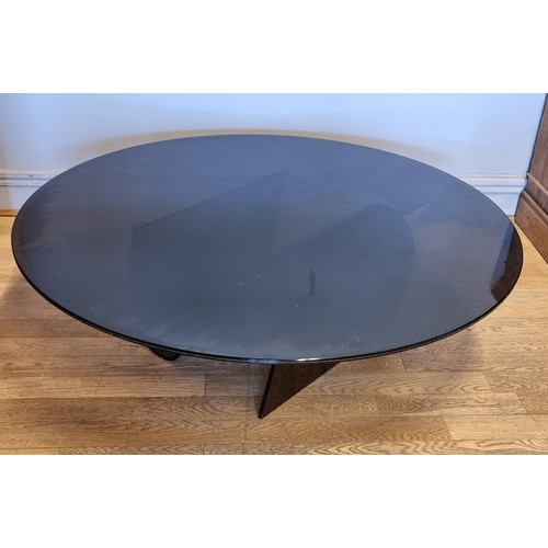 55 - A modern stylised smoked glass occasional/coffee table.
109cm diameter.
