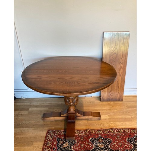 60 - A solid oak extending pedestal dining table, with leaf.
111cm diameter, extended 149cm long.