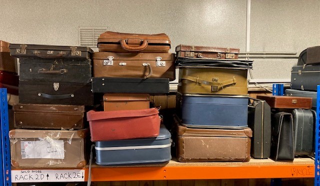 A large collection of early 20th century and later suitcases ...