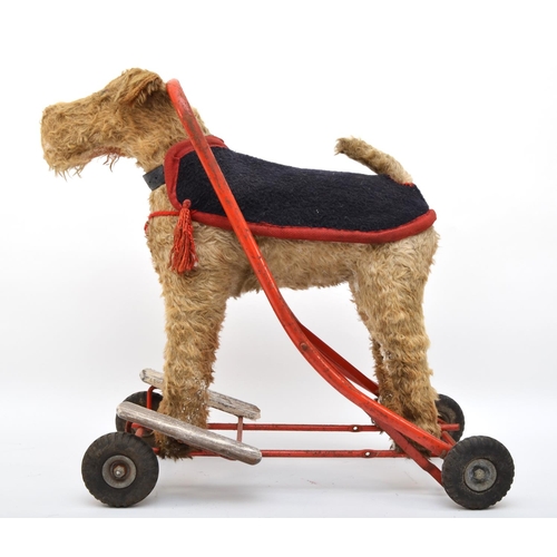 359 - A ride on push along child's toy, in the form on a dog, westie, with collar and jacket, with wooden ... 