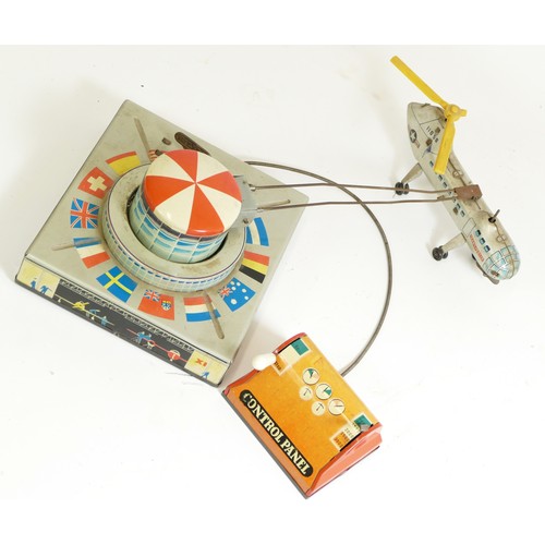 376 - A Biller tinplate remote controlled helicopter, made in Germany, transporter helicopter orbiting a a... 