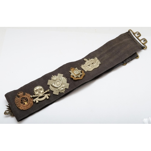 441 - A collection of 13 military cap badges, mounted on a belt to include Australian , 9th Lancers and 16... 