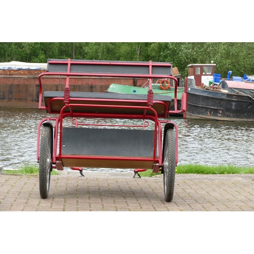 151 - A red painted horse/pony exercise cart, with English leather harness