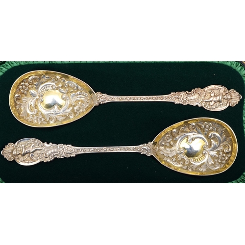 2 - A Victorian silver pair of embossed and chased serving spoons, London 1898, cast handles with cherub... 