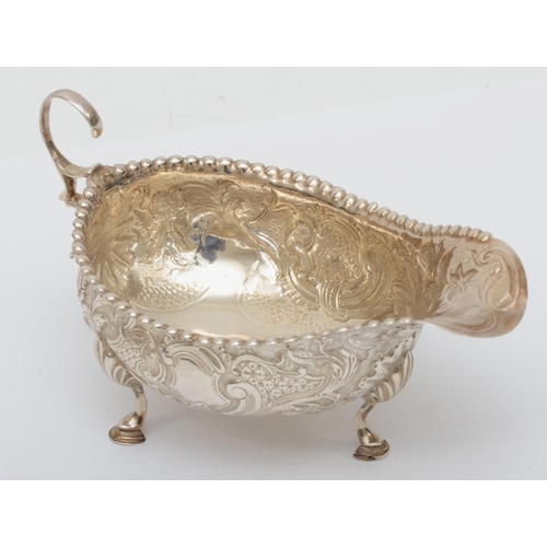 64 - A George III silver sauce boat, By Peter and Ann Bateman, London 1791, later embossed and chased wit... 