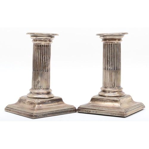 45 - A Victorian silver pair of Corinthian column desk candlesticks, Sheffield 1890, raised on beaded bas... 