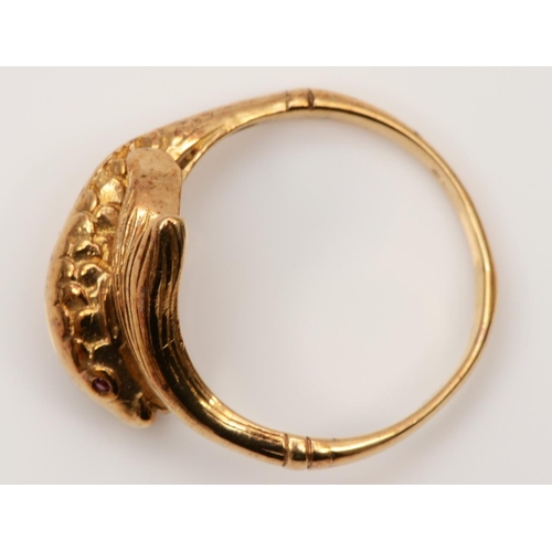 80 - An 18ct gold coiled fish ring, London 1977, lacking carat mark, with textured body and ruby eyes, P ... 