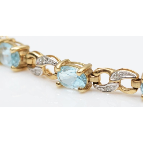 112 - A 9ct gold diamond and blue topaz line bracelet, the oval mixed cut stone with two single cut diamon... 