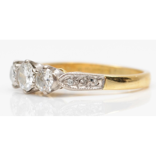 114 - An 18ct gold three stone diamond ring, London 1976, claw set with brilliant cut stones, approximatel... 