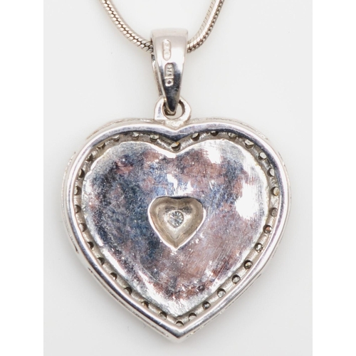 123 - A 9ct white gold, enamel and diamond heart shape pendant, the brilliant cut stone within a blue fiel... 