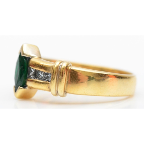 130 - An 18K gold emerald and blue diamond (untested for colour) dress ring, set with a navette stone flan... 