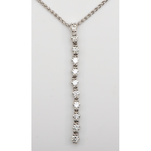 186 - An 18K white gold and diamond line pendant, 40mm, claw set with nine brilliant cut diamonds, total w... 