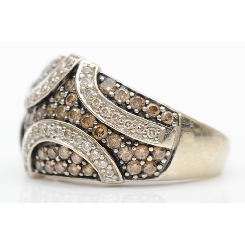 188 - A 14KT white gold and diamond set dress ring, pave set with white and champagne brilliant cut stones... 