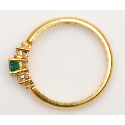 149 - An 18ct gold emerald and diamond ring, claw set with an emerald cut stone flanked by brilliant cut t... 