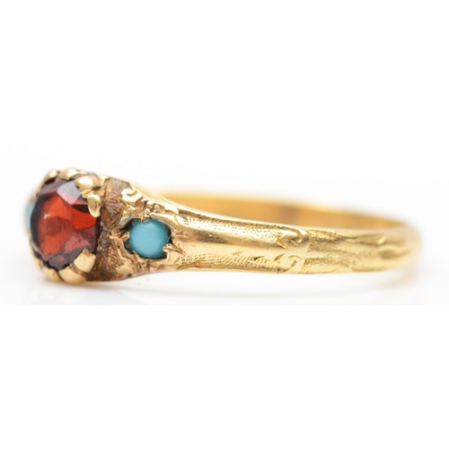 145 - A Victorian gold, garnet and turquoise three stone ring, carved shoulders, N, 1.6gm