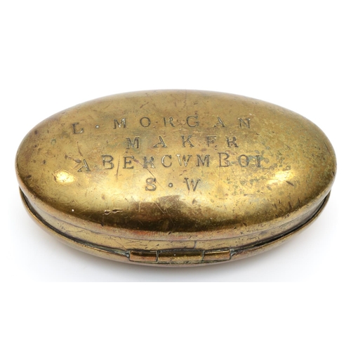 223 - An Edwardian Welsh brass oval tobacco box, by L. Morgan, Maker, Abercwmboi, S.W., the hinged lid eng... 