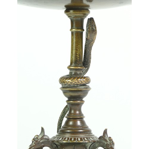 233 - A bronze tazza, the tripod base of sphinxes with climbing snake on a central baluster upright, raise... 