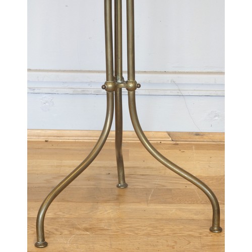 236 - An Edwardian rotating magazine rack, the brass tripod base with mahogany and with three brass divide... 