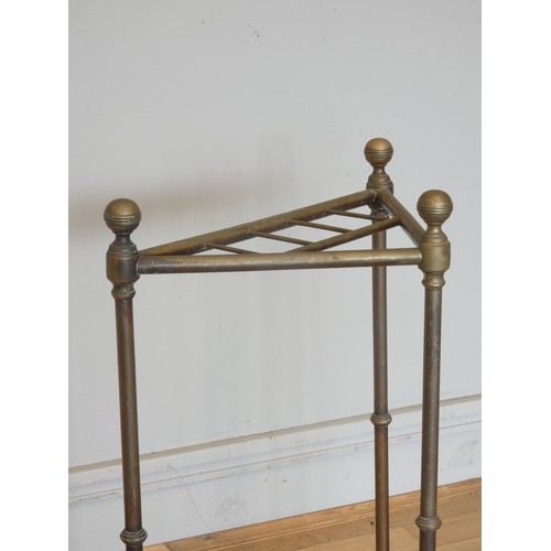 237 - An Edwardian brass corner umbrella stand, with four divisions on a cast iron base with inset drip tr... 