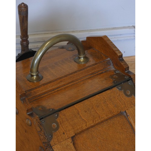 238 - An Edwardian oak coal scuttle, the panelled fall-front with brass handles and mounts, complete metal... 