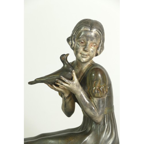 245 - An early 20th century spelter figure of a seated girl with a dove, raised on a marble base, 30 x 12 ... 