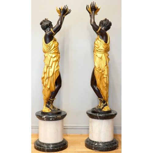 248 - An impressive pair of cast bronze female Blackamoor torcheres, the ladies in gilt dresses holding bo... 