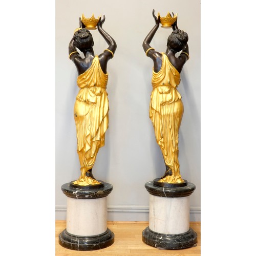 248 - An impressive pair of cast bronze female Blackamoor torcheres, the ladies in gilt dresses holding bo... 