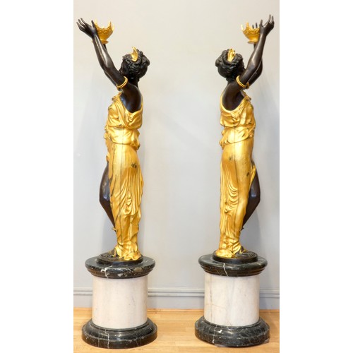 248 - An impressive pair of cast bronze female Blackamoor torcheres, the ladies in gilt dresses holding bo... 