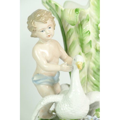 277 - A late 19th century German porcelain vase, depicting a boy standing next to a flower bud shaped vess... 