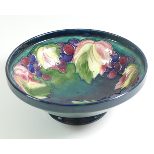 285 - A Moorcroft dish raised on a pedestal, leaf and berry pattern, singed W. Moorcroft on the base, 16.5... 