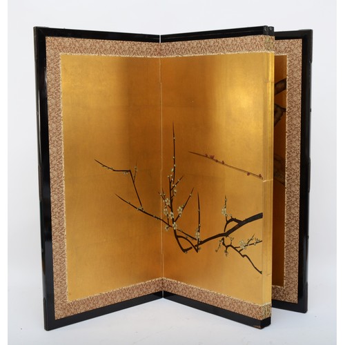 323 - A Japanese byobu gold paper folding screen divider, four panels with ebonised frame depicting birds ... 