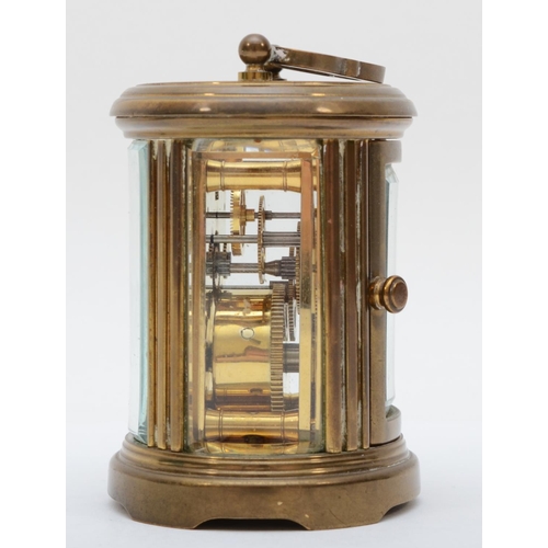 359 - A brass eight day carriage clock of oval form, retailed by Matthew Norman of London. 8cm tall.