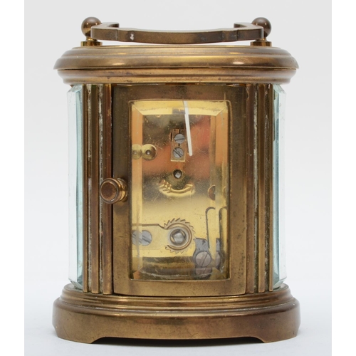 359 - A brass eight day carriage clock of oval form, retailed by Matthew Norman of London. 8cm tall.