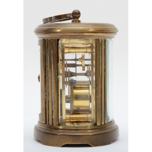 359 - A brass eight day carriage clock of oval form, retailed by Matthew Norman of London. 8cm tall.