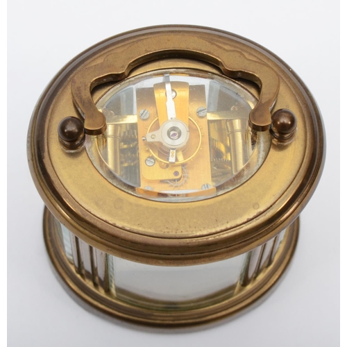 359 - A brass eight day carriage clock of oval form, retailed by Matthew Norman of London. 8cm tall.