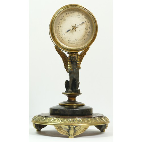 393 - A late 19th century brass aneroid barometer, raised on a bronzed patinated sphinx, to a brass stand ... 