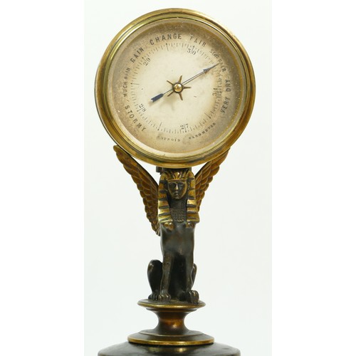 393 - A late 19th century brass aneroid barometer, raised on a bronzed patinated sphinx, to a brass stand ... 