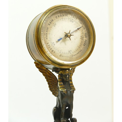 393 - A late 19th century brass aneroid barometer, raised on a bronzed patinated sphinx, to a brass stand ... 