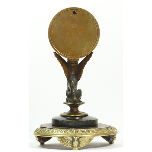 393 - A late 19th century brass aneroid barometer, raised on a bronzed patinated sphinx, to a brass stand ... 