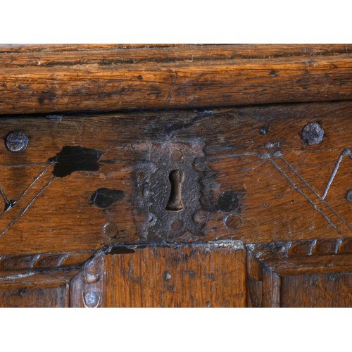 538 - A 17th century and later oak coffer, the planked hinged lid over four foliate carved recessed panels... 