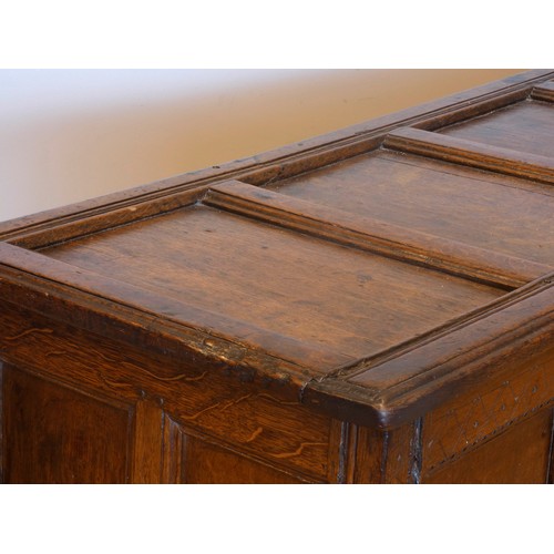 538 - A 17th century and later oak coffer, the planked hinged lid over four foliate carved recessed panels... 