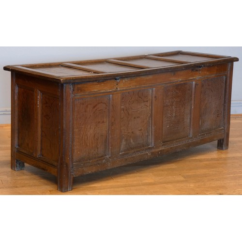 538 - A 17th century and later oak coffer, the planked hinged lid over four foliate carved recessed panels... 