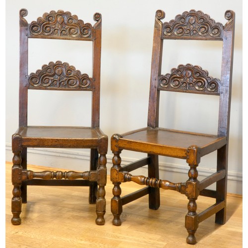 547 - A pair of 18th century oak Yorkshire chairs, the definite back crests with voluted scrolls and centr... 