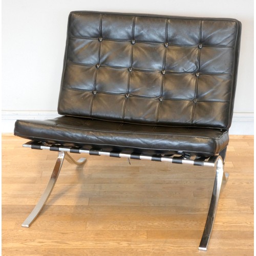 574 - A Robert Haussmann inspired Barcelona lounge chair and ottoman, upholstered black leather with butto... 