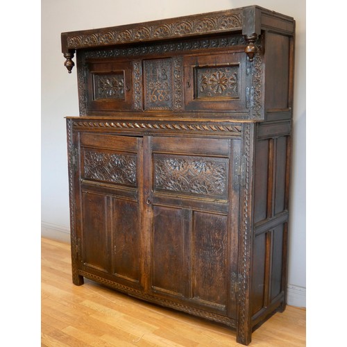 563 - Charles II and later oak press or court cupboard, dated 1688, the canopy top with inverted finials a... 