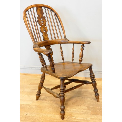 564 - A 19th century elm and yew wood hoop back Windsor chair, the stick back centred with a pierced splat... 