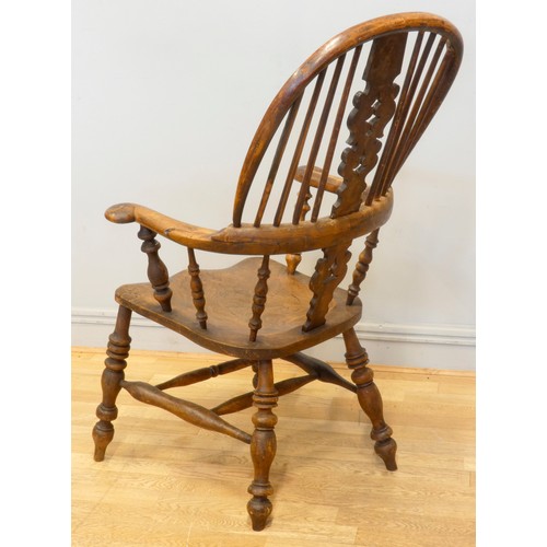 564 - A 19th century elm and yew wood hoop back Windsor chair, the stick back centred with a pierced splat... 